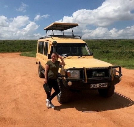 Dame steht am Jeep während ihrer gebuchten Privat Safari